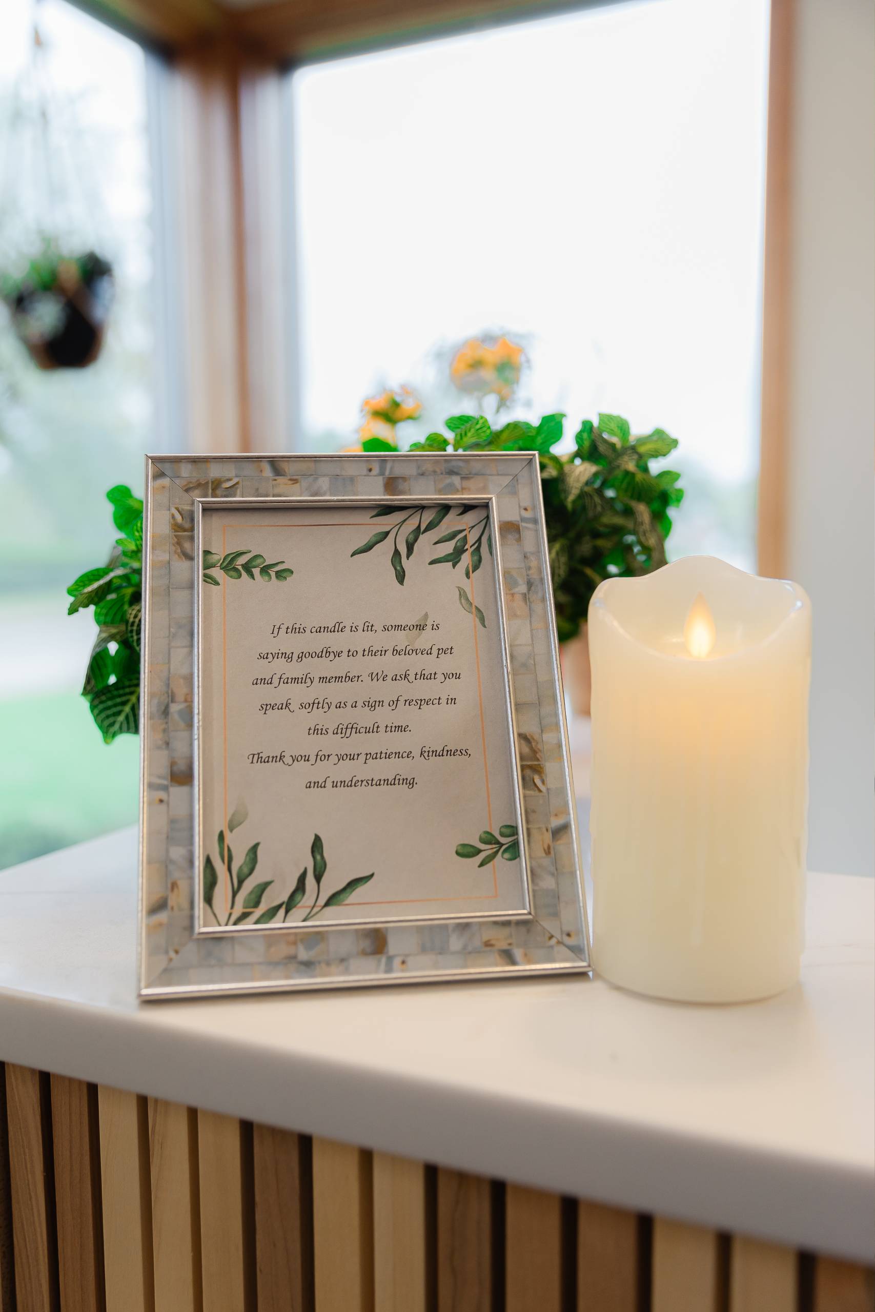 A framed picture of a candle and a flower, adding warmth and beauty to any space